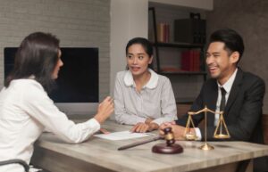 Profissional de advocacia conversando com um casal de clientes em uma sala de atendimento para advogados.