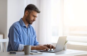 Homem usando computador em casa e aproveitando seu endereço virtual.