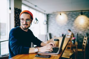 Futuro das profissões​: homem trabalhando em área comum de coworking.