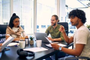 Flexibilidade no trabalho​: três pessoas trabalhando em coworking.