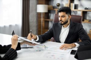 Empresário assinando documento, representando quanto custa não ter uma sala de reunião profissional.